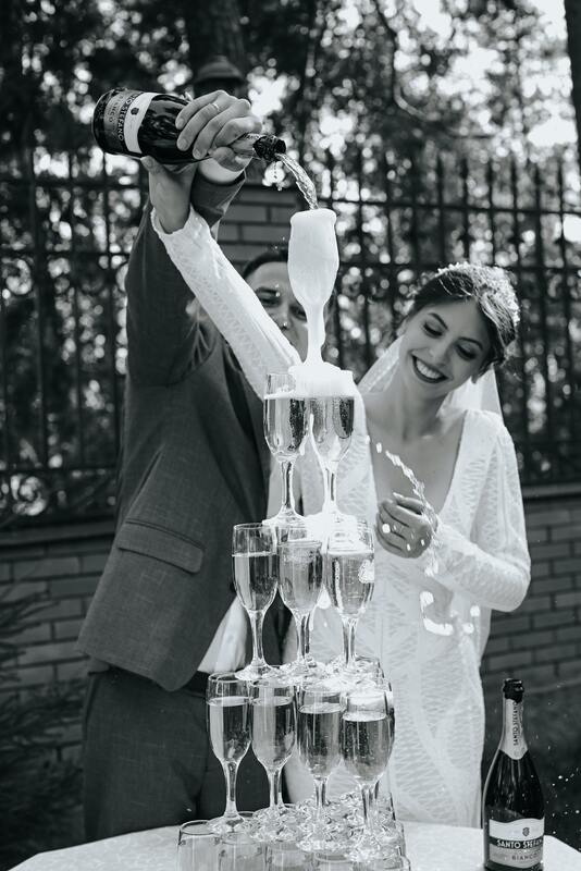 Bride and Groom pouring champagne over a champagne tower